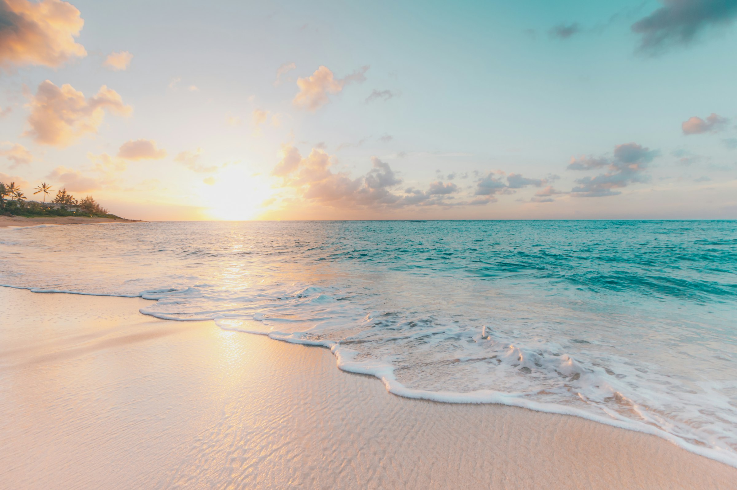 Amanecer en una playa de arena blanca con palmeras