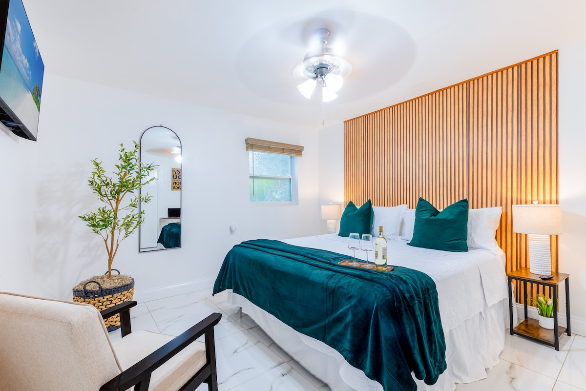 Recámara con cama king, cabecera de madera y detalles en verde