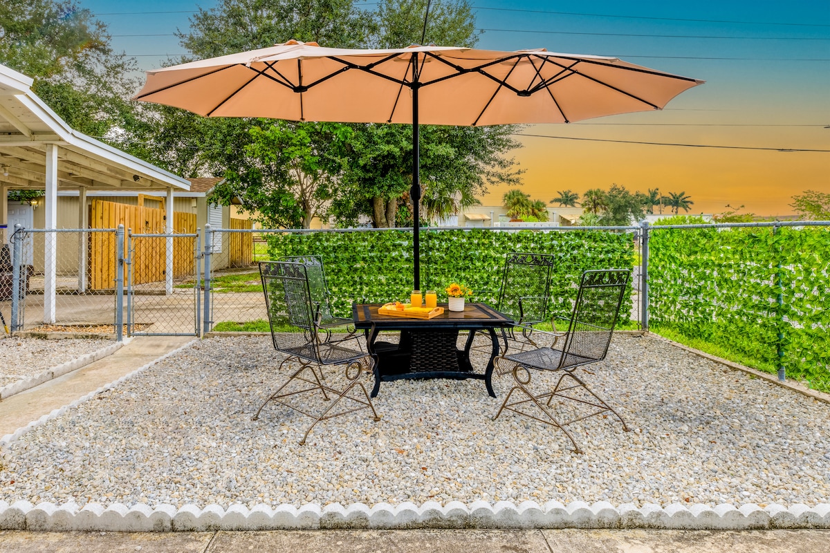 Patio con mesa, sombrilla y atardecer