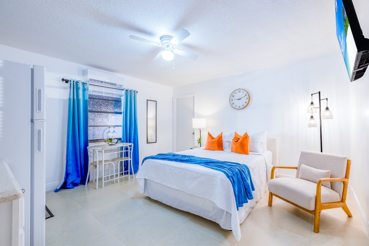 Studio blanco con almohadas naranjas y cortinas cian
