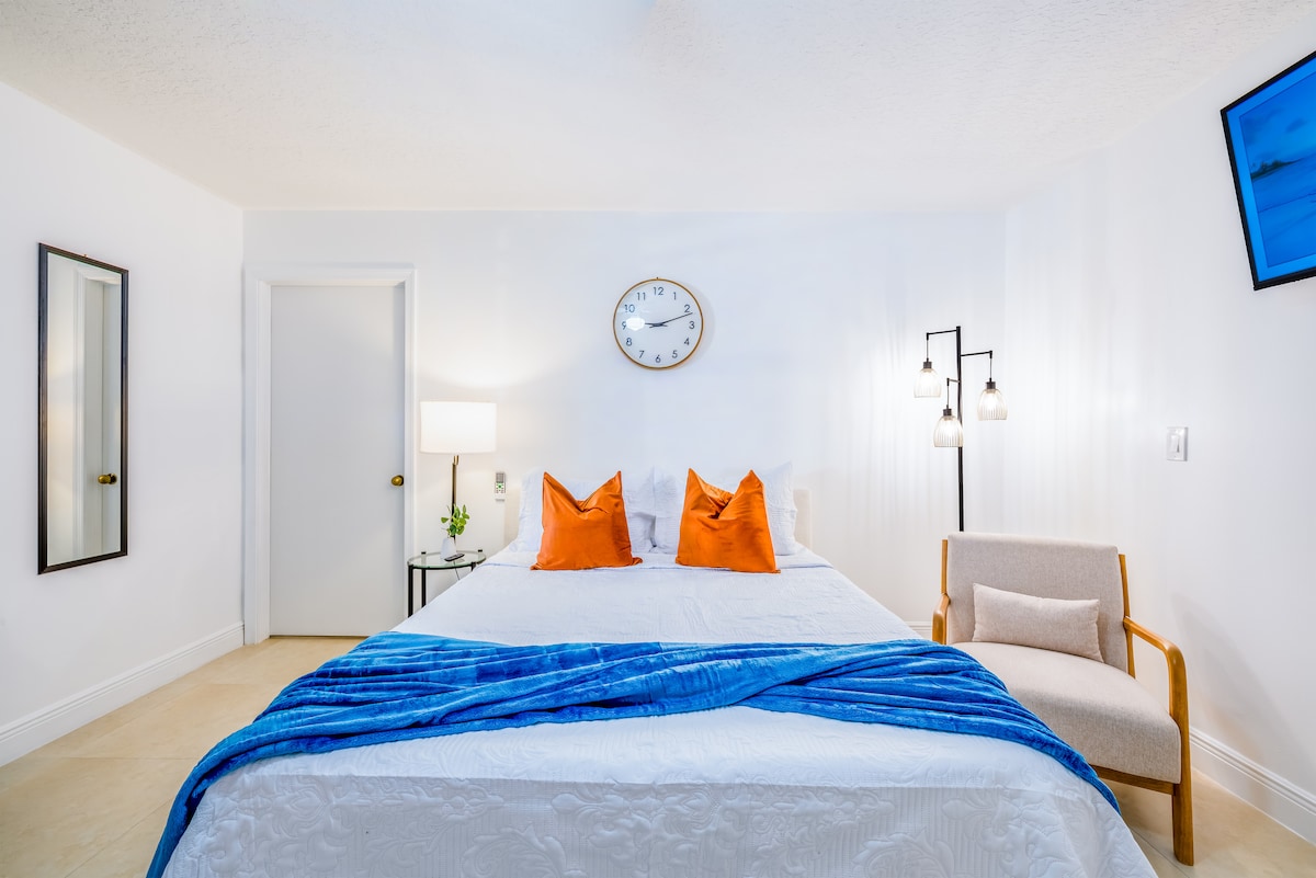 Cama con cobija azul y sillón